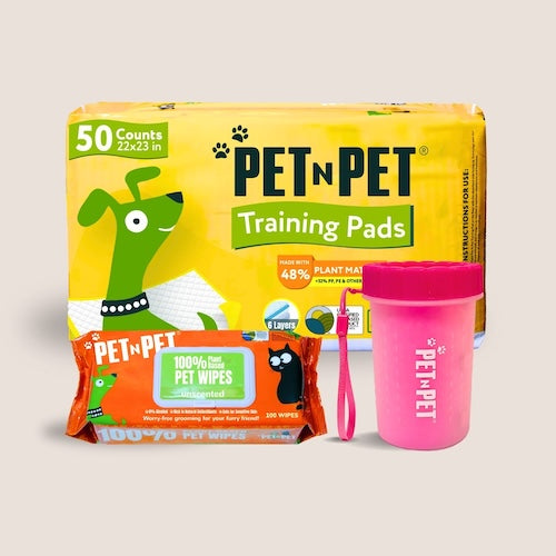 Pet N Pet product bundle on a bright green background, featuring a 50-count pack of 22x23 inch training pads (48% plant-based), a pack of 100 unscented 100% plant-based pet wipes, and a blue Pet N Pet poop bag dispenser with a wrist strap.