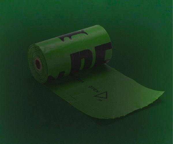 Green roll of poop bag with a logo on a green background 