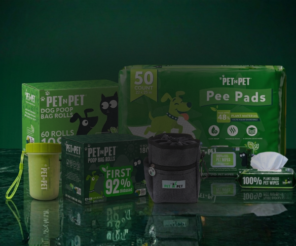 Collection of Pet-N-Pet pet care products including bags, pee pads, and wipes on a reflective surface with a green background.