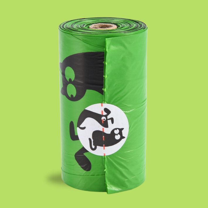 Roll of green pet waste bags with black and white illustrations on a green background
